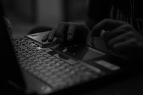 A computer with hands on the keyboard, generic image